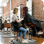 Hair stylist trims her client’s hair inside a modern salon